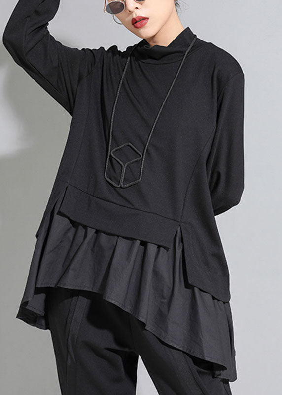 Modell bär den asymmetriska långärmade toppen, visar dess passform och damblusens stil.
