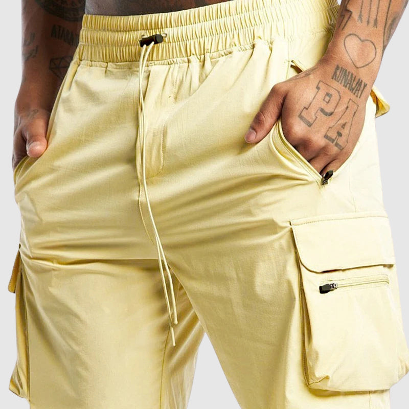 Slitstarka herrshorts med dragsko och lastfickor, designade för utomhusträning och aktiv fritid.