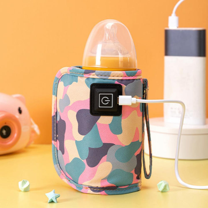 Övre vy av kamouflage USB-värmare som håller en babyflaska varm, viktigt babytillbehör.