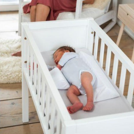 Närbild på babytillbehör: mjuk och andningsbar säkerhetskudde mot rullning för barnrummet