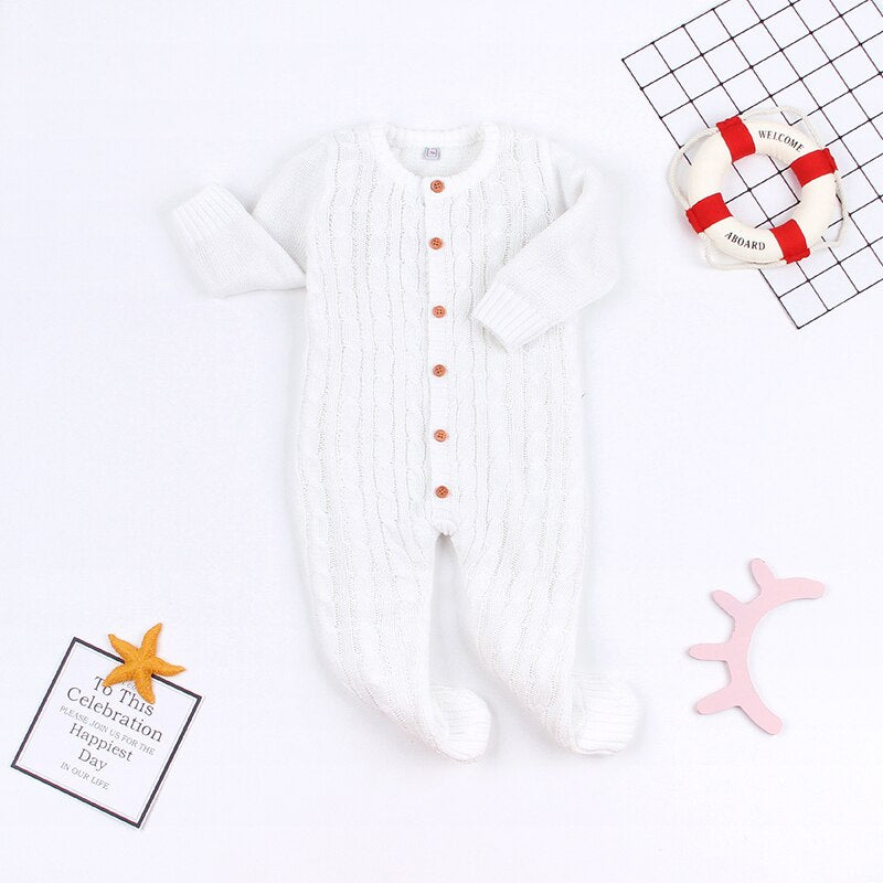 Detaljbild av en mysig stickad romper för baby, med elegant mönster och mjuk textur.