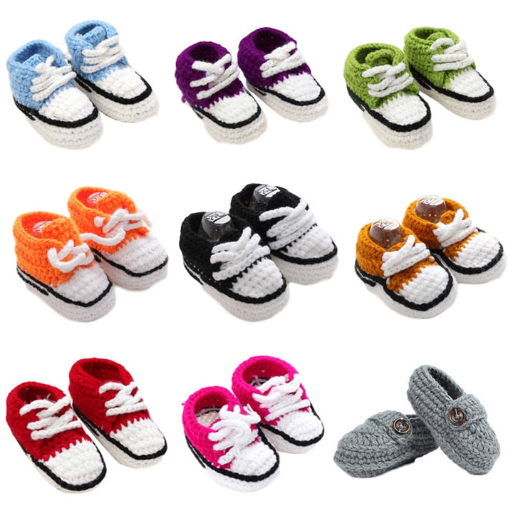 Samling av färgglada baby stickade snörskor i olika nyanser: rosa, blå, grå, bekväma barnskor