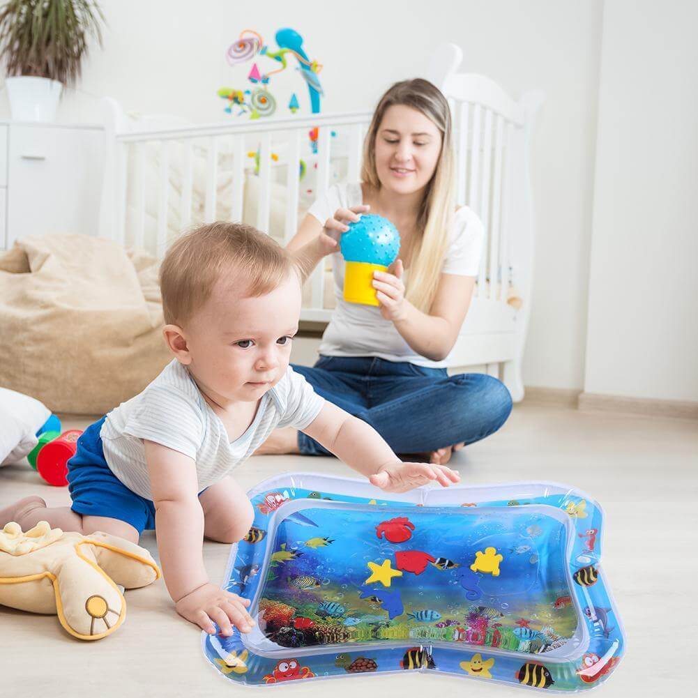 Närbild på en baby som leker på en vattenmatta, tränar nacke och ryggmuskler.