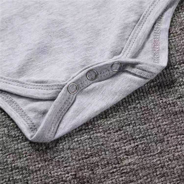 Rockstarbaby onesie med detaljerade tatueringstryck på armarna, mjuk och bekväm för baby.