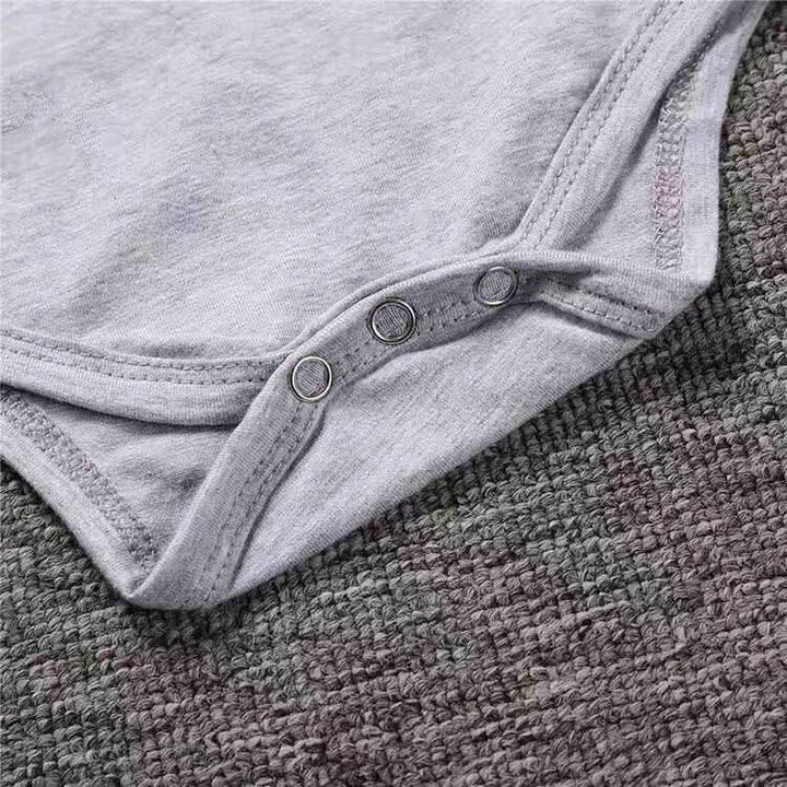 Rockstarbaby onesie med detaljerade tatueringstryck på armarna, mjuk och bekväm för baby.