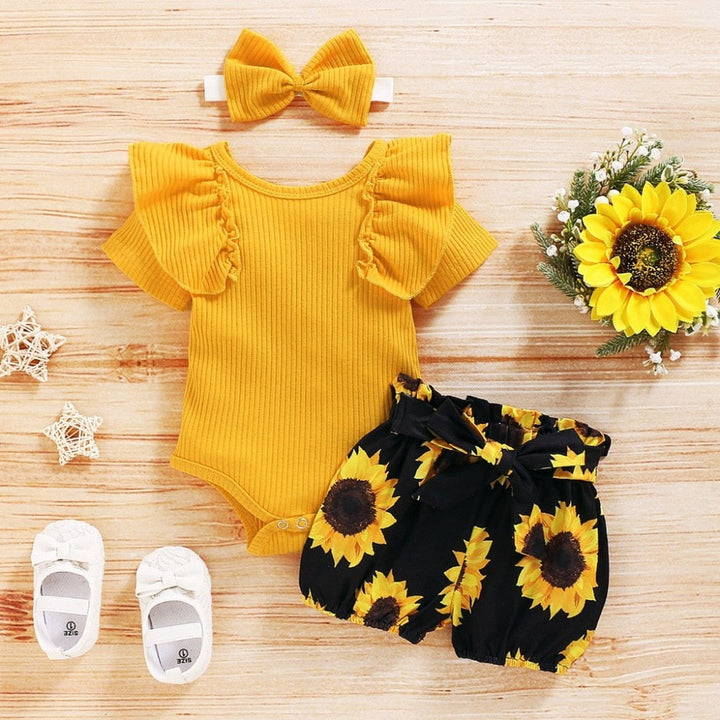 Sött bomullsset för nyfödda med färgglada solrosor, idealiskt som babyshowerpresent.
