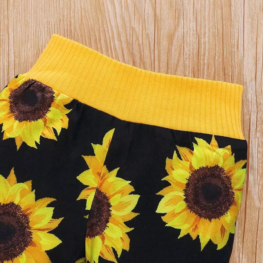 Baby i solrosset av bomull, rörande sig bekvämt och fritt på golvet.