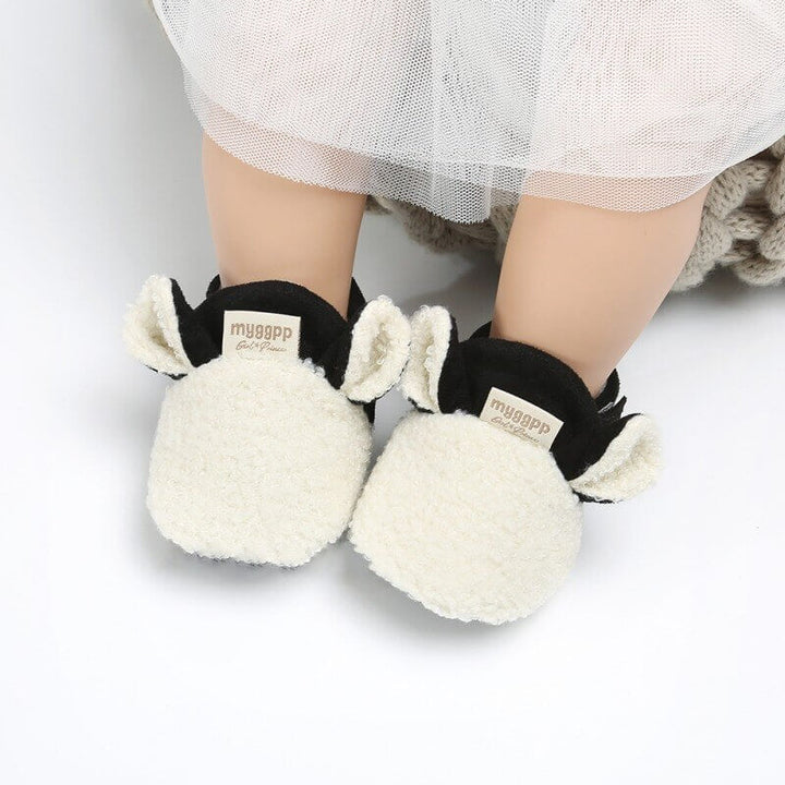 Närbild av lammdesign på babyskor, broderade detaljer för barnskor
