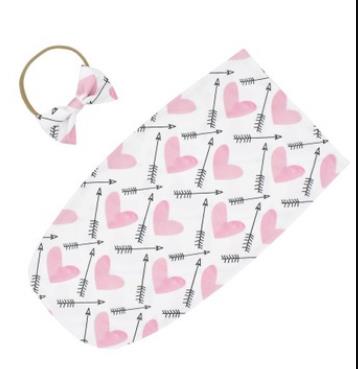 Närbild på en söt rosett på spädbarns huvudband, matchar mysig swaddle