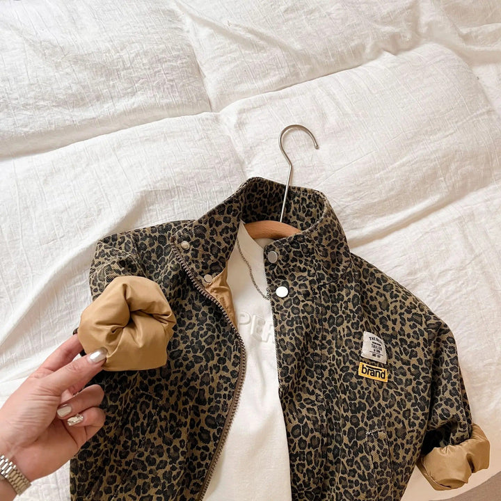 Detaljbild av en barnjacka i denim med unikt leopardmönster, stilrent flickmode.