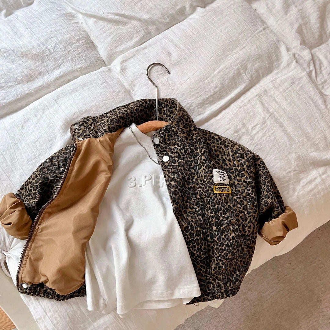 Barnjacka med mjukt denimtyg och distinkt leopardmönster, idealisk för vardag och fest.