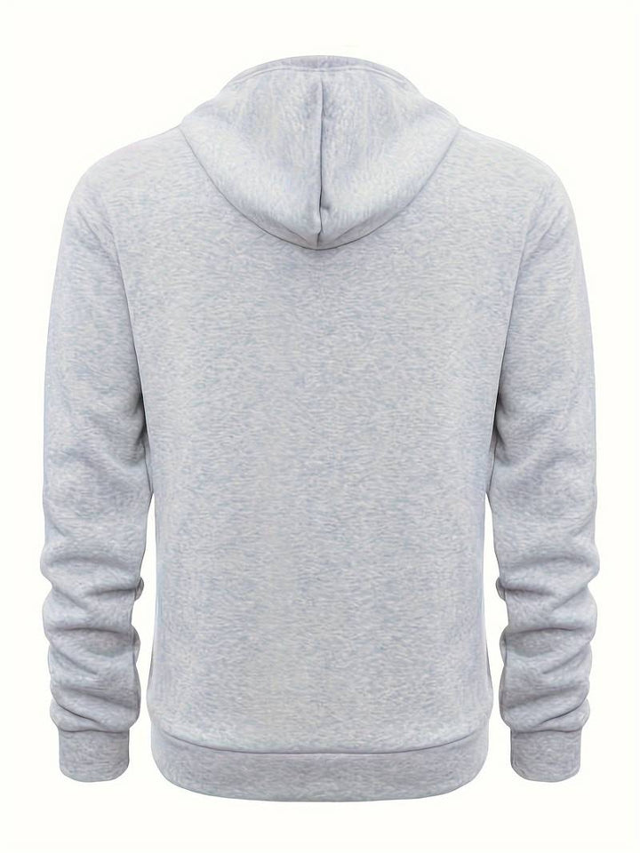 En man i avslappnad herrhoodie rör sig bekvämt, visar den lediga passformen och vardagsstil.