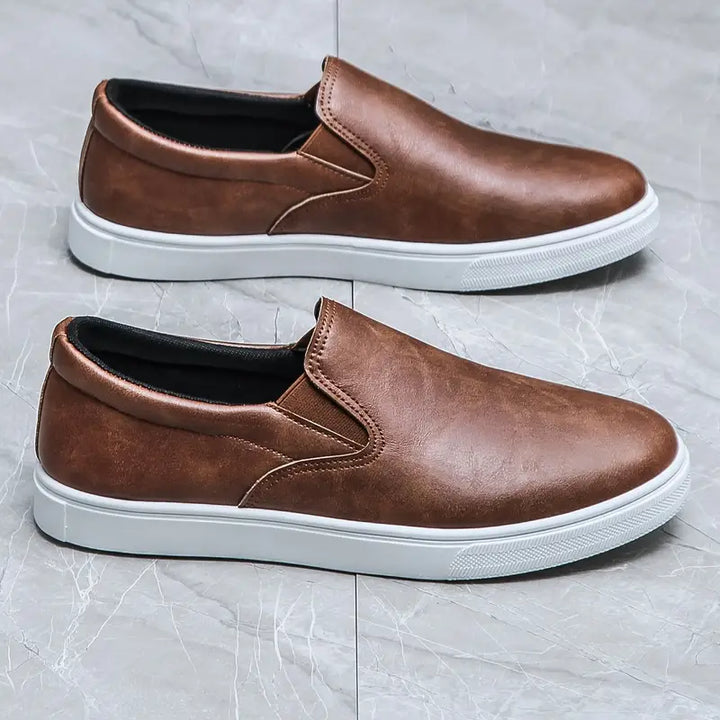 Man bär bekväma herrslippers, visar upp deras stilrena design och funktionalitet för en avslappnad livsstil.