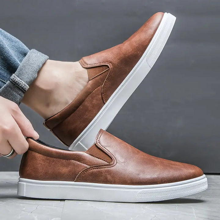Herrtofflor i tidlös design, utmärkta som bekväma slip-on skor för både hemmet och lättare utomhusbruk.