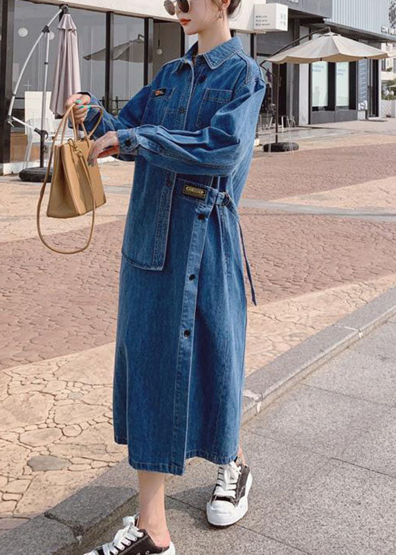 Elegant blå långklänning med asymmetrisk fåll, långa ärmar och praktiska fickor. Perfekt för höstens vardagsmode.