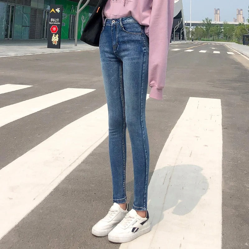 Kvinnomodell i blå klassiska stretchjeans med hög midja, rak passform. Bekväma vardagsjeans.