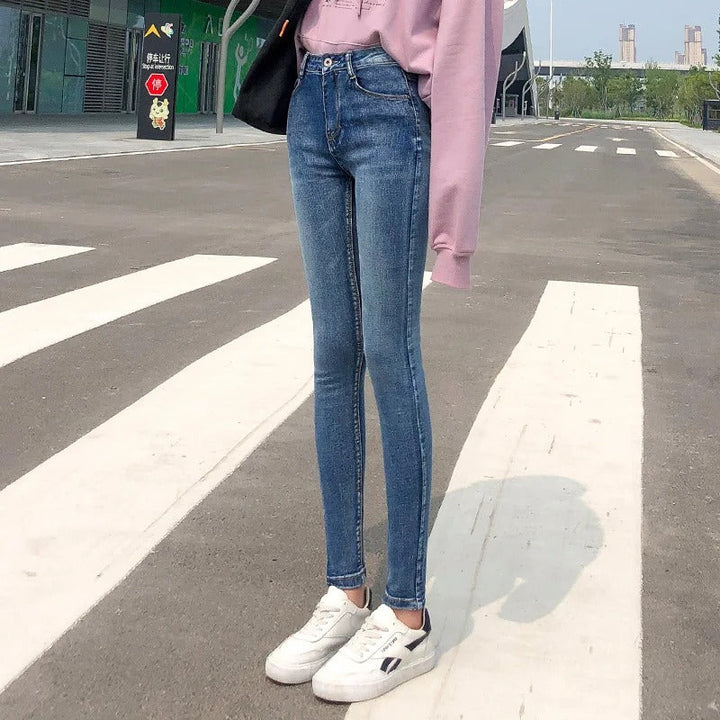 Kvinnomodell i blå klassiska stretchjeans med hög midja, rak passform. Bekväma vardagsjeans.