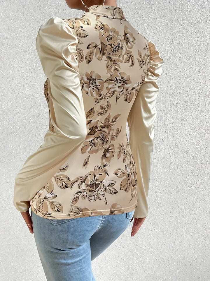 Feminin blommönstrad damtopp med elegant skärning. Stilfull blus perfekt för både kontoret och fritiden.