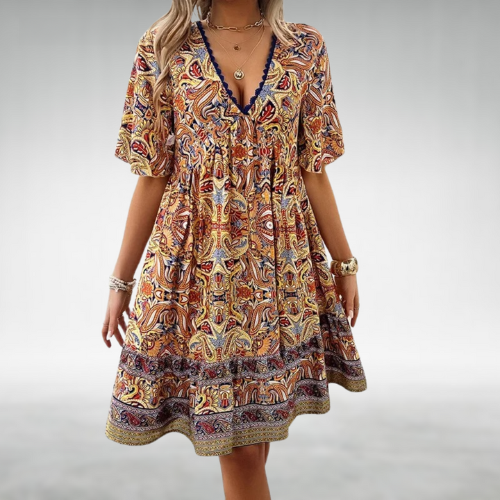 Närbild av färgglad boho miniklänning med detaljerat paisleymönster. Idealisk för avslappnade sommardagar eller festival.