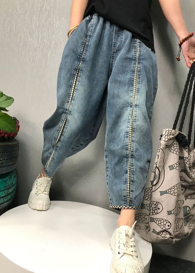Detaljerad bild av kvinnors boho denimbyxor med lapptäcke i olika denimbelag, idealiska för vardagsbruk.