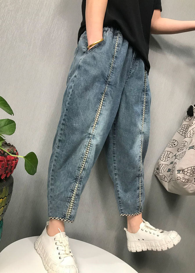 Modell bär kvinnors avslappnade patchwork denimbyxor som framhäver den unika designen och komforten.