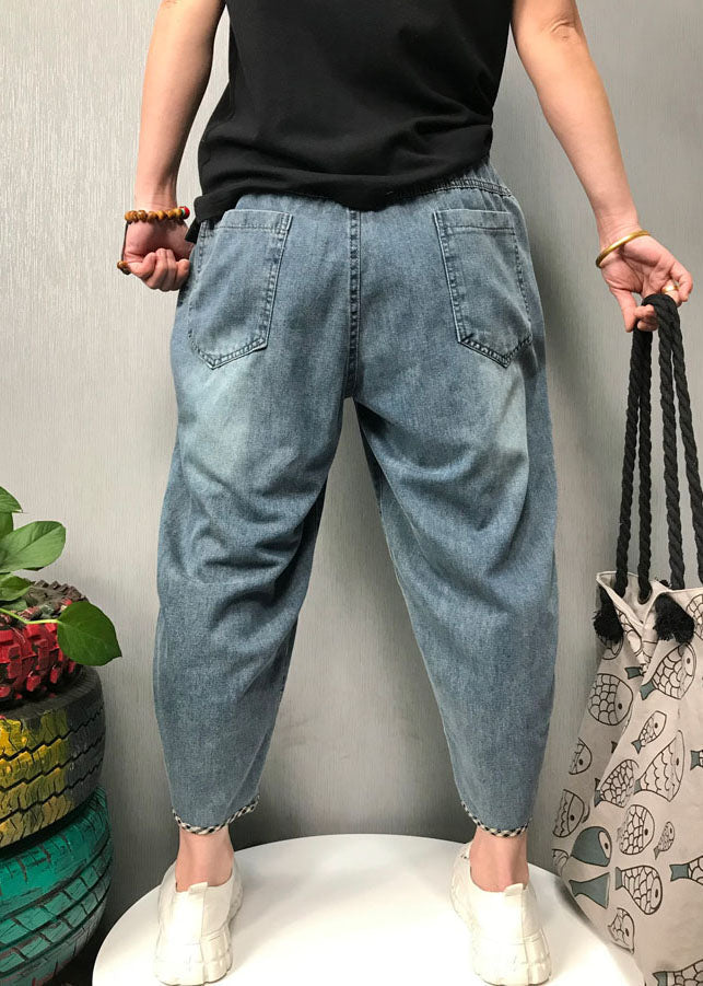 Närbild på tyget av kvinnors boho patchwork denimbyxor, visar sömmar och denimnyanser för en sommarlook.