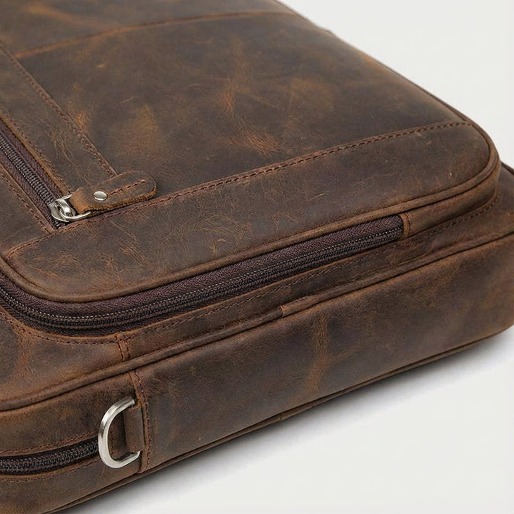 Stor brun vintageinspirerad datorväska i läder för arbete och resor. Unisex och hållbar med plats för 17-tums laptop.