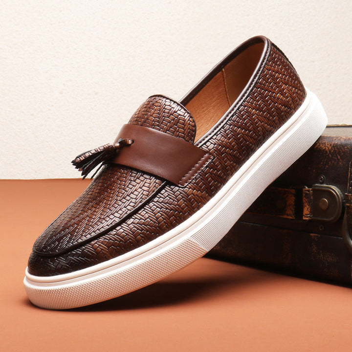 Närbild på bruna tofsar på en stilren slip-on herr-loafer. Mjuka och bekväma fritidsskor.