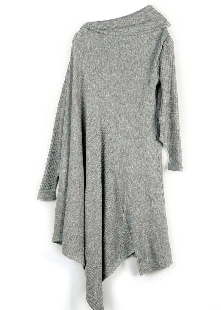 Kvinna i elegant svart asymmetrisk tröjaklänning med hög hals. Chic och modern design för kvinnor.
