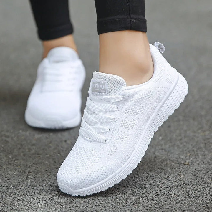 Dam andningsaktiva fritidssneakers fotograferade ovanifrån, framhäver den moderna designen och snörningen.
