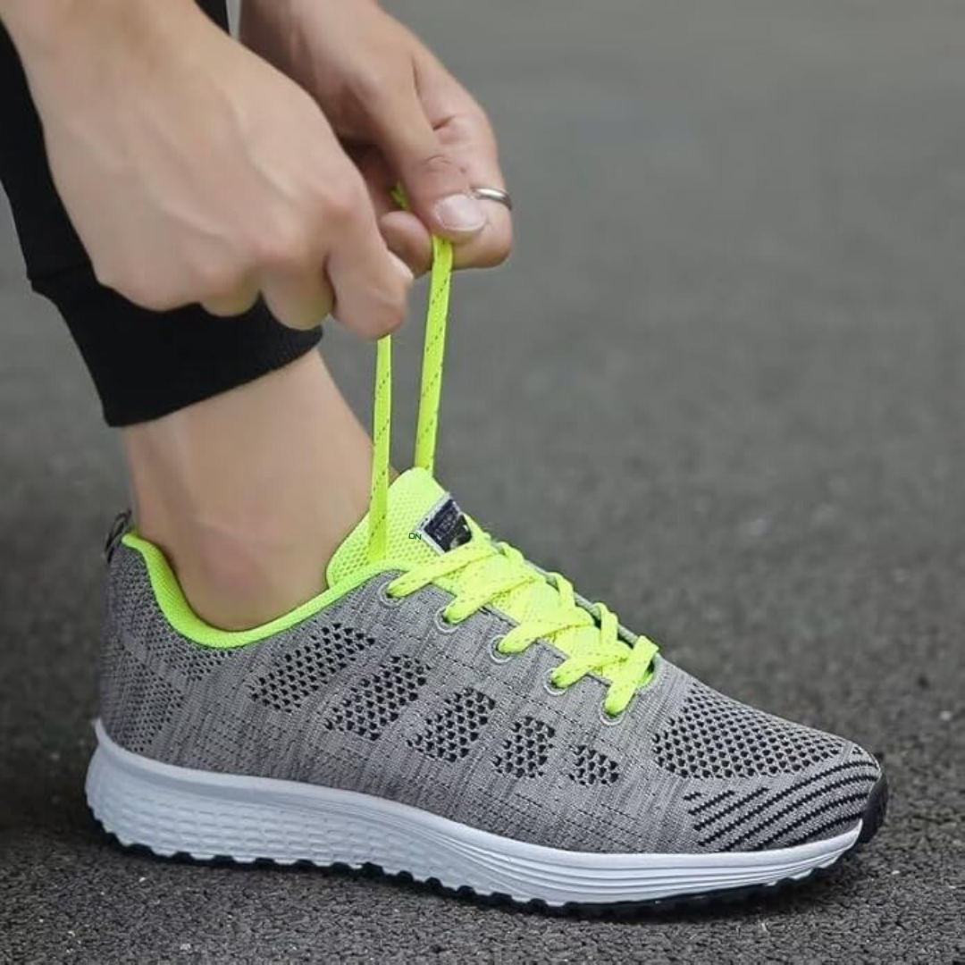 En kvinna som bär dam andningsaktiva fritidssneakers går på en stig, visar deras funktionella komfort.