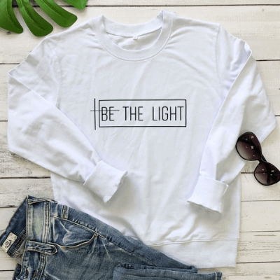 Frontbild: "Be the Light" damtröja, modern långärmad sweatshirt i mjuk bomull/polyester. Statementplagg.