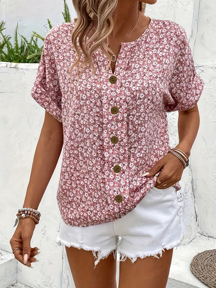 Modell bär en mångsidig damtopp med kort ärm och knappar, stylad för en avslappnad sommarlook.