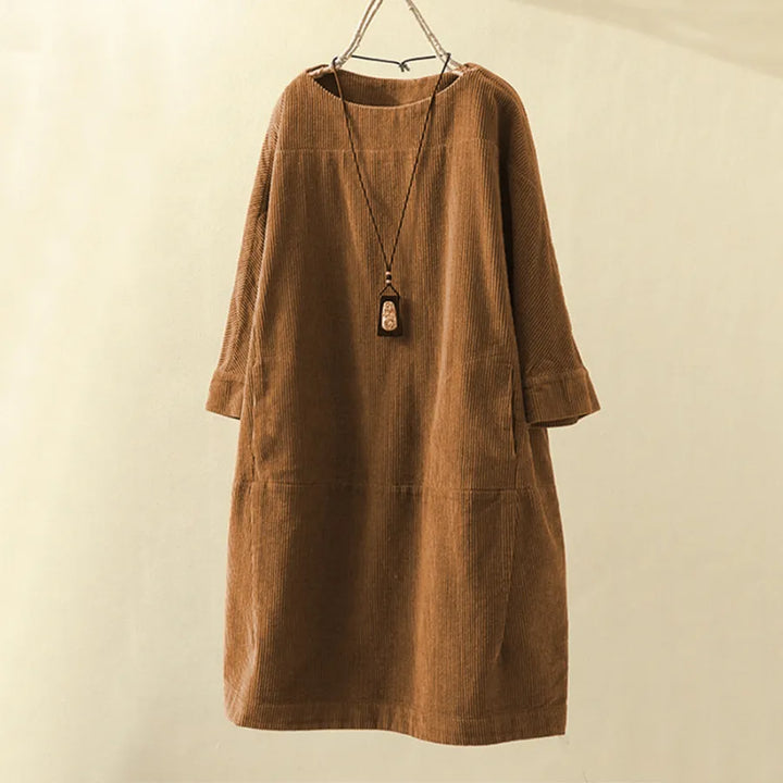 Elegant knälång manchesterklänning för kvinnor, mörkgrönt tyg, långärmad design som andas höstmode.