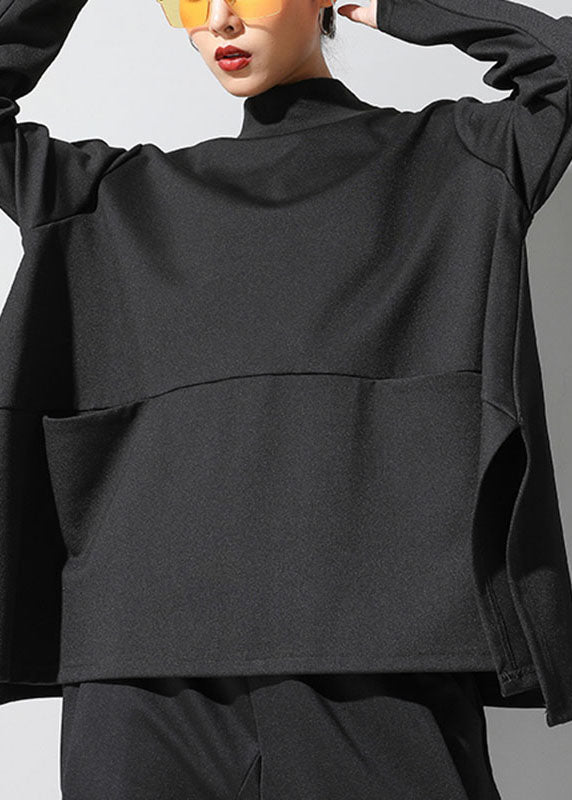 Trendig svart damtopp med långa ärmar, öppna sidoslitsar och fickdetaljer, idealisk för en avslappnad look.