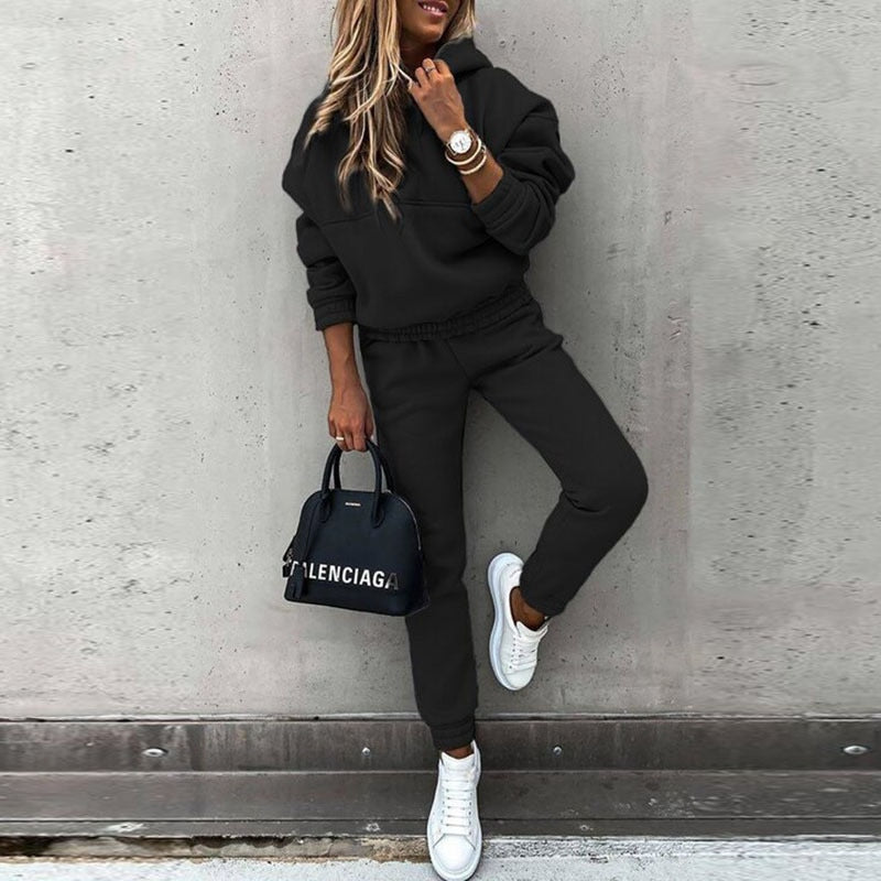 Kvinnors fritidsset i mjukt material med en rymlig hoodie och figurnära byxor.