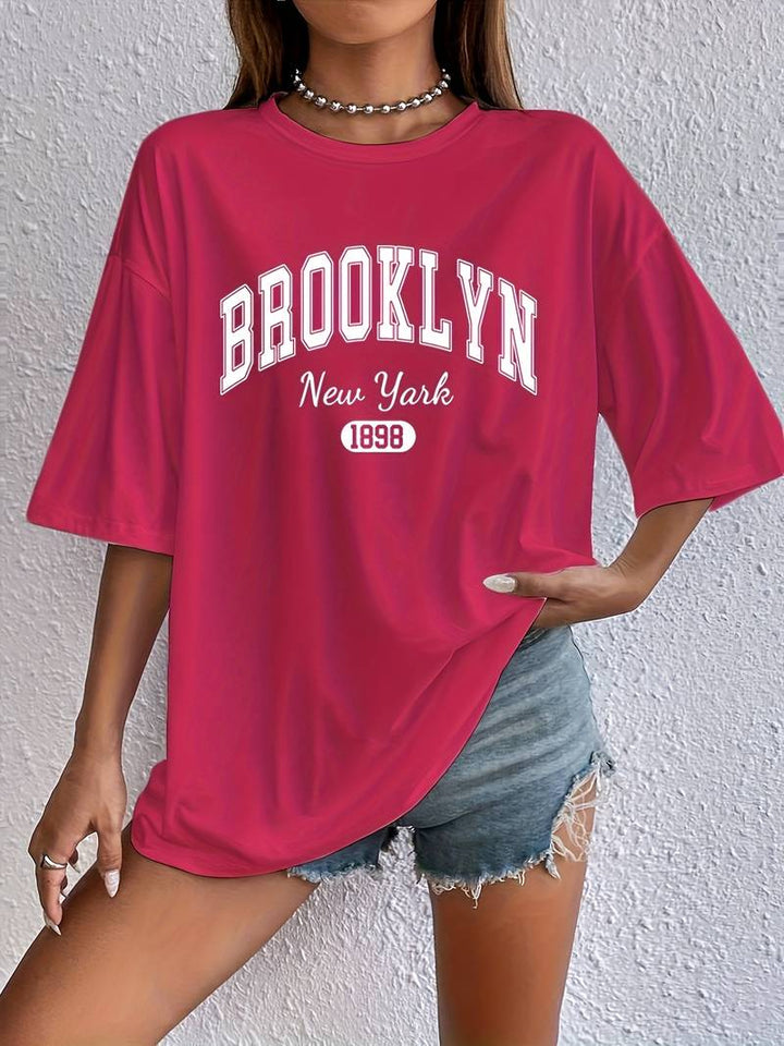 Kvinna bär avslappnad Brooklyn t-shirt med rund hals, kort ärm. Perfekt för trendig sommarlook.