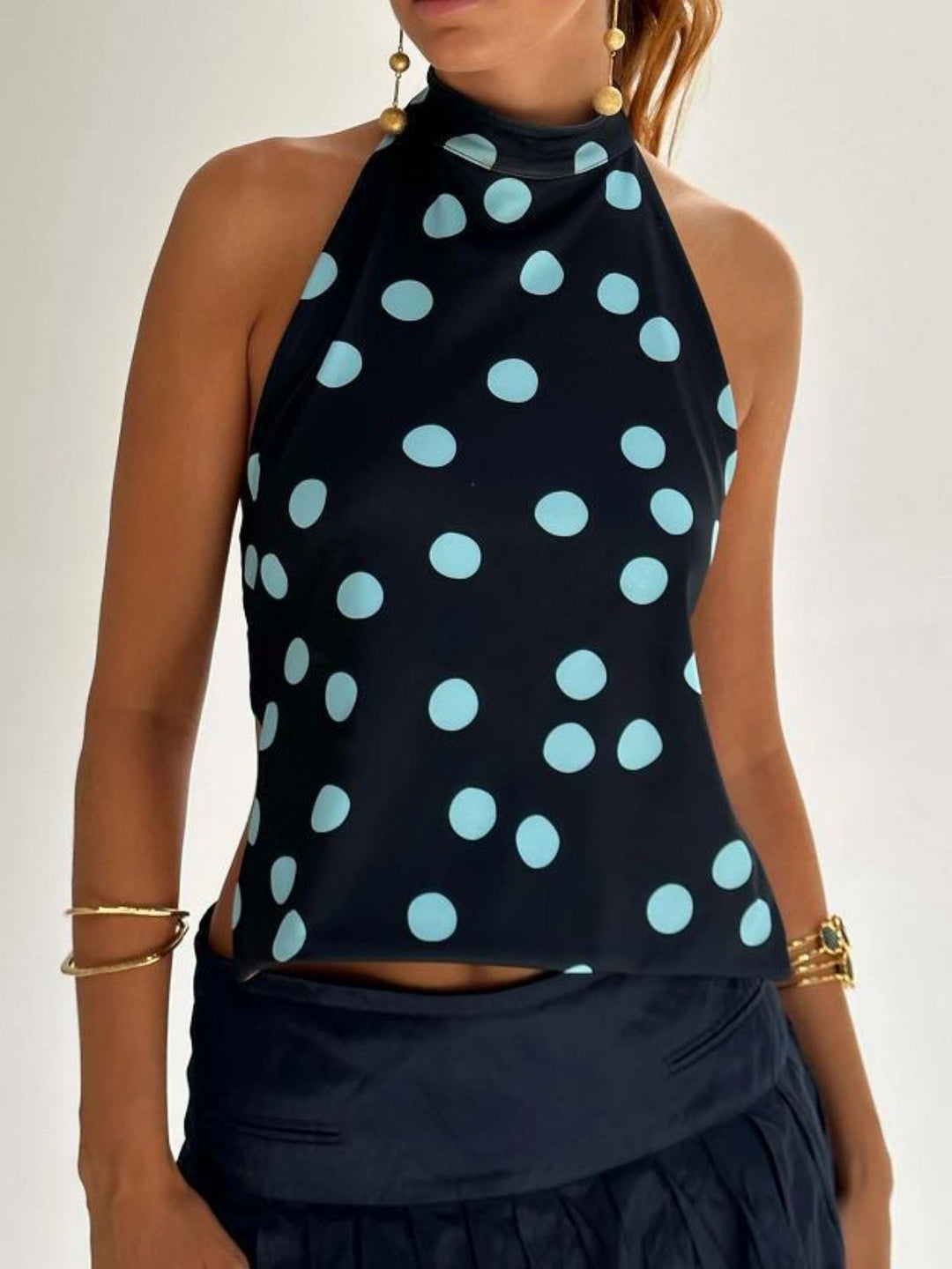 Elegant dam tanktop med halterneck, tryckt design och rygglös passform.