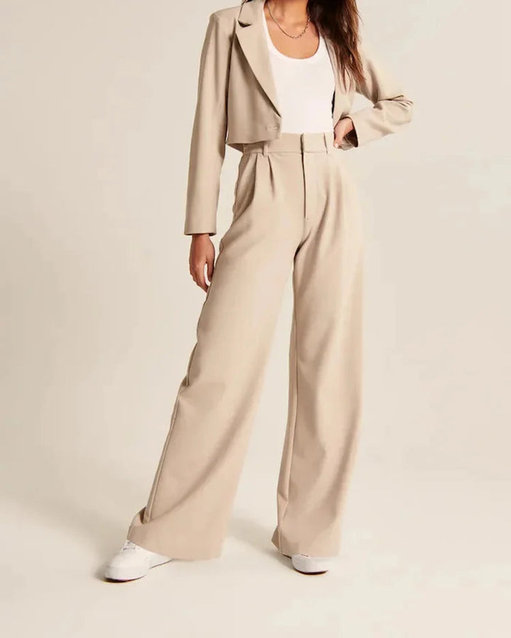 Närbild på tyget av bekväma dambyxor hög midja, vida ben i elegant beige färg.