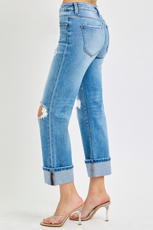 Närbild av rakbenade damjeans med mellanhög midja och detaljerad uppvikt fåll i slitstark denim.