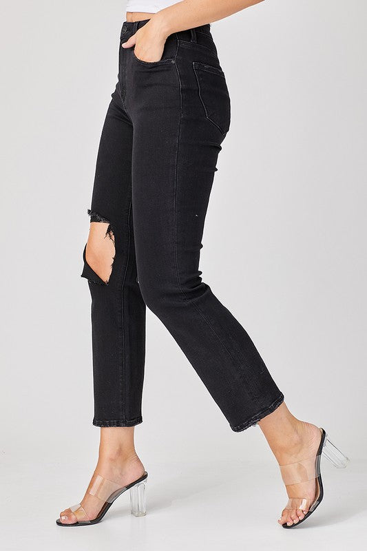 Modell bär svarta modejeans i sliten denim, avslappnad passform, för en chic streetwear-look.