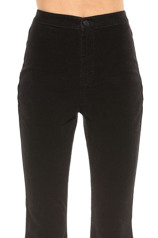 Modell bär bekväma damjeans i svart kordflöjel med hög midja för en snygg vardagslook.