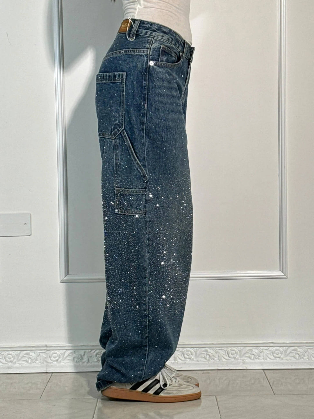 Modell som bär damjeans med diamond-detaljer, framvisar passform och stil i avslappnad pose.