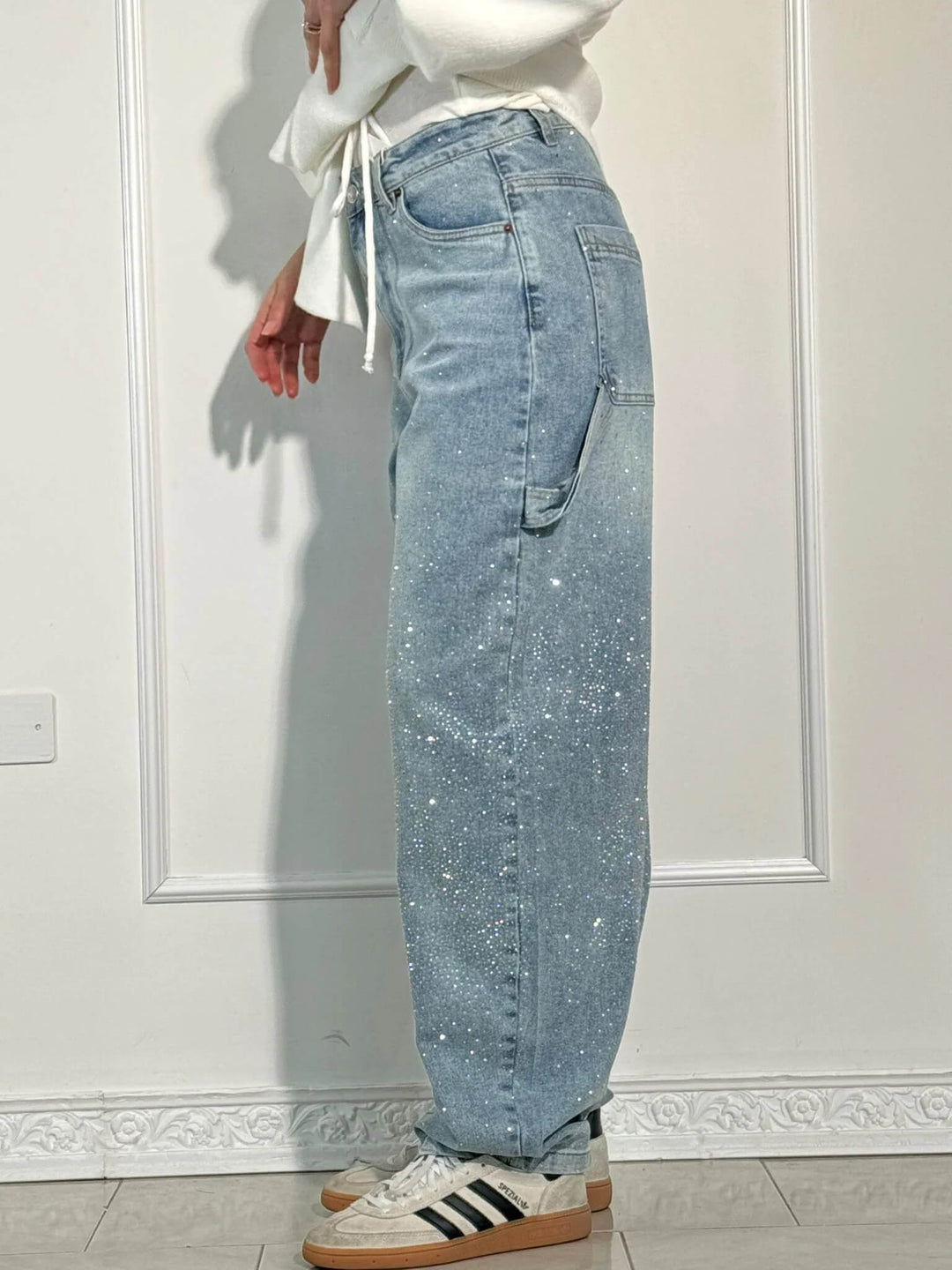 Damjeans med diamond-detaljer liggande platt, visar hela plagget och materialkvaliteten.