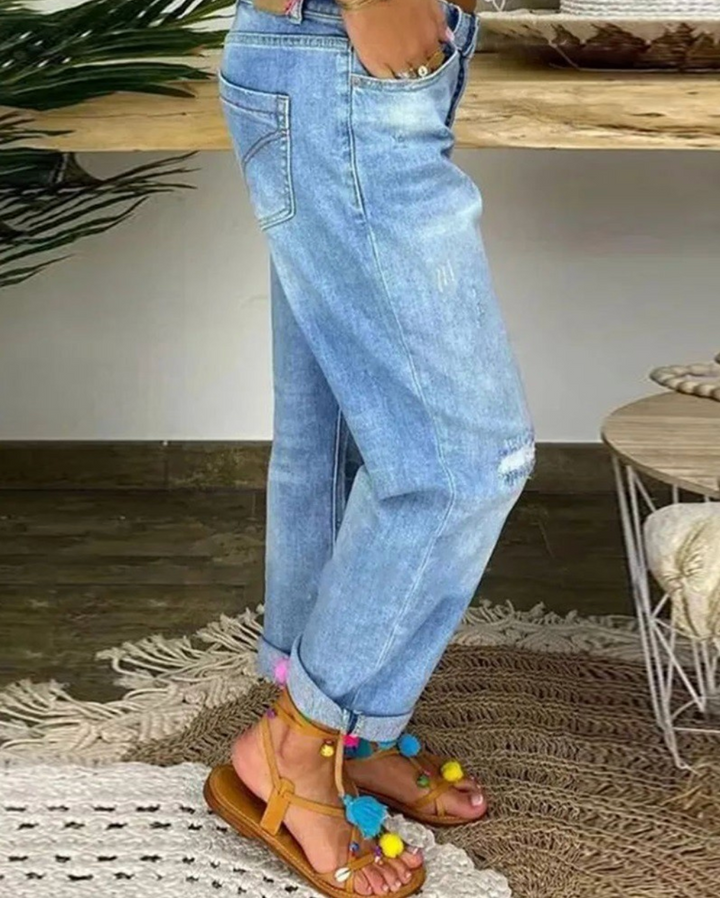Närbild av klassiska damjeans med hög midja, visar denimtextur och detaljer. Bekväma damjeans.