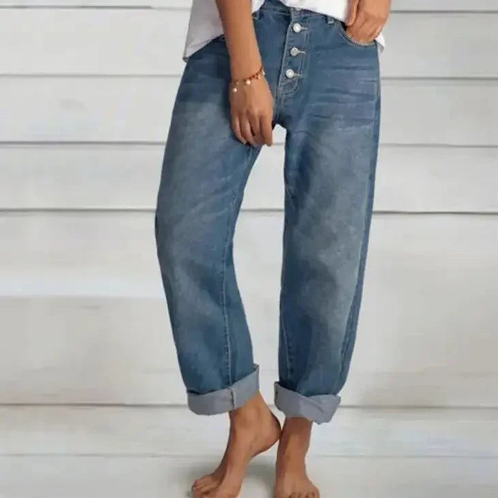 Närbild av tyget på damjeans med hög midja, framhäver kvalitet och den avslappnade texturen.