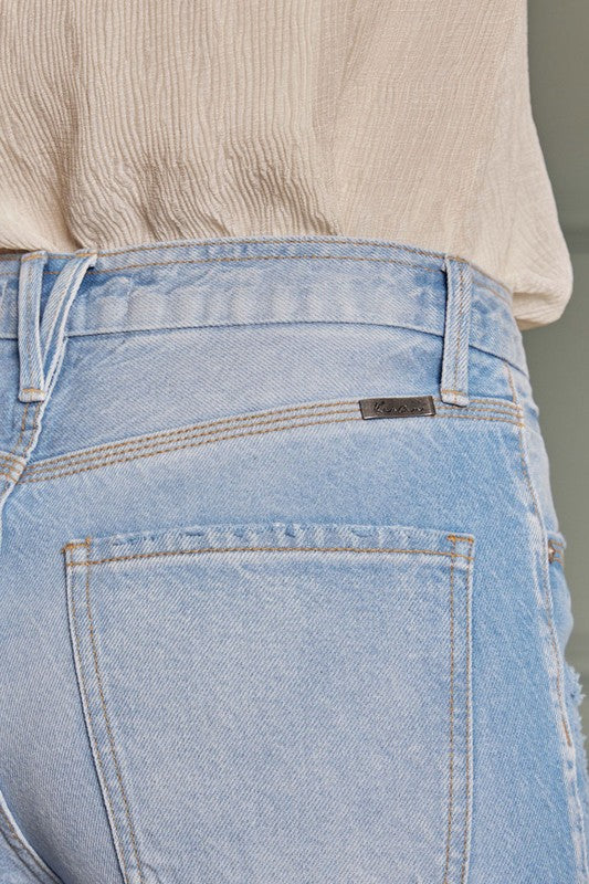 Detaljbild på högmidjade flared damjeans i ljus denim, accentuerar tyget