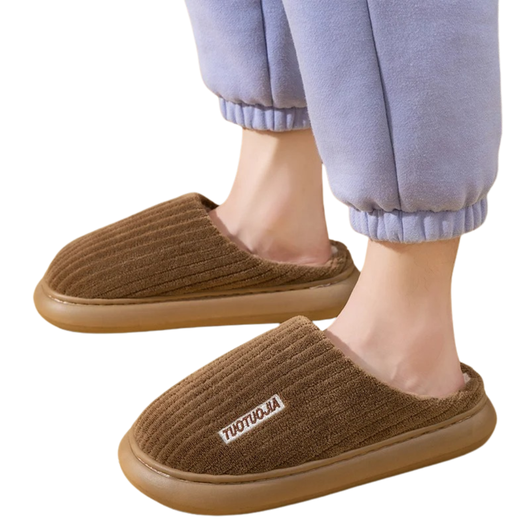 En kvinna som bär de beige damtofflorna i plysch. Mysiga memory foam inneskor.