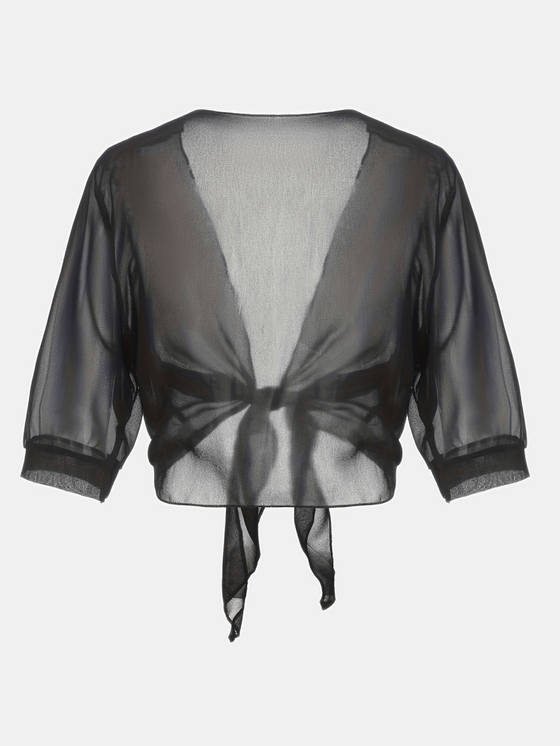 Elegant damtopp med öppen front i mild färg, perfekt sommarblus för en sofistikerad look.