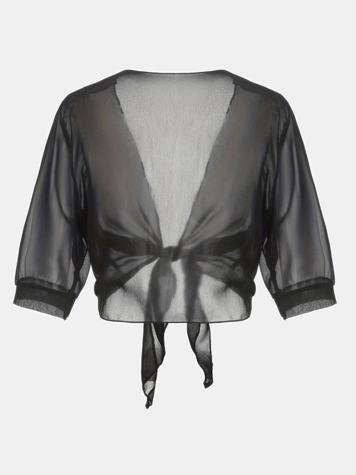 Elegant damtopp med öppen front i mild färg, perfekt sommarblus för en sofistikerad look.